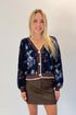 Front view of woman wearing Swagger Boutique’s Navy & Brown Printed Cardigan with Brown Faux Leather Mini Skirt against white studio background.