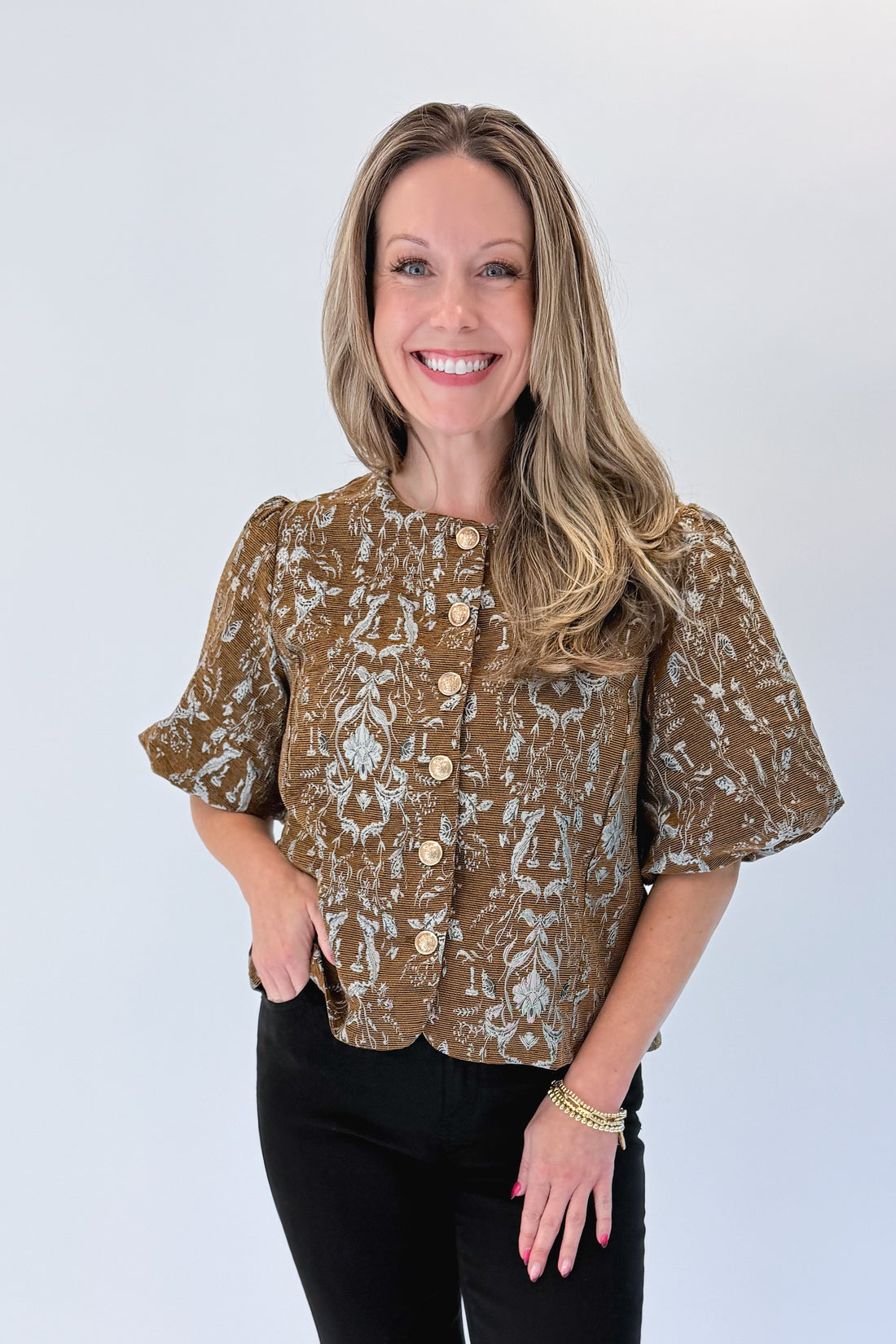 Front view of woman wearing Swagger Boutique’s Brown Floral Corduroy Top with jeans against white studio background.