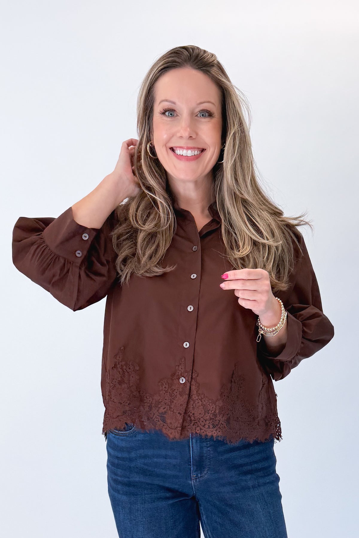 Front view of woman wearing Swagger Boutique’s Brown Lace Lined Button Up Top by Entro with jeans against white studio background.