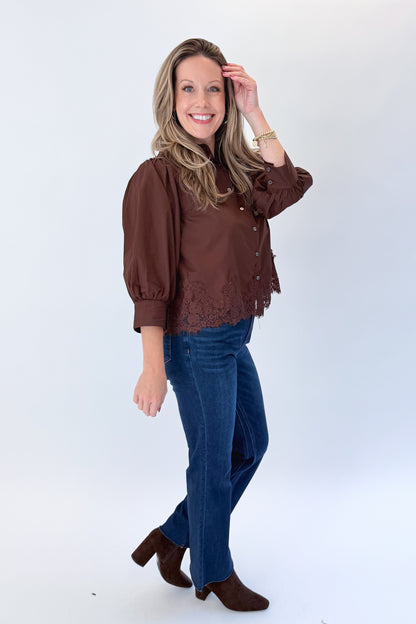 Side view of woman wearing Swagger Boutique’s Brown Lace Lined Button Up Top by Entro with jeans against white studio background.
