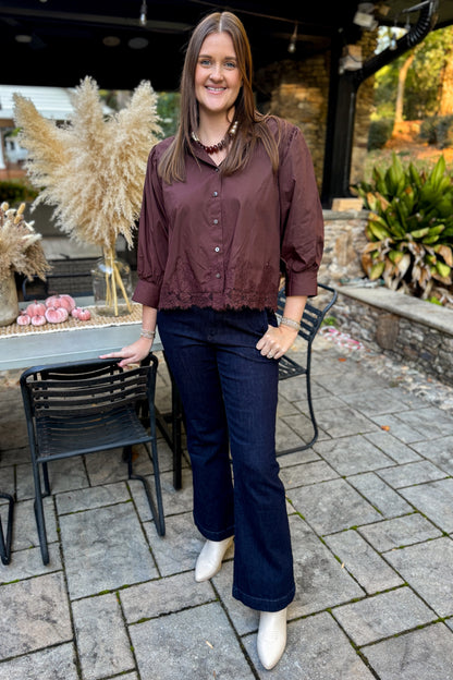 Front view of woman wearing Swagger Boutique’s Brown Lace Lined Button Up Top by Entro with jeans standing outside at a party.