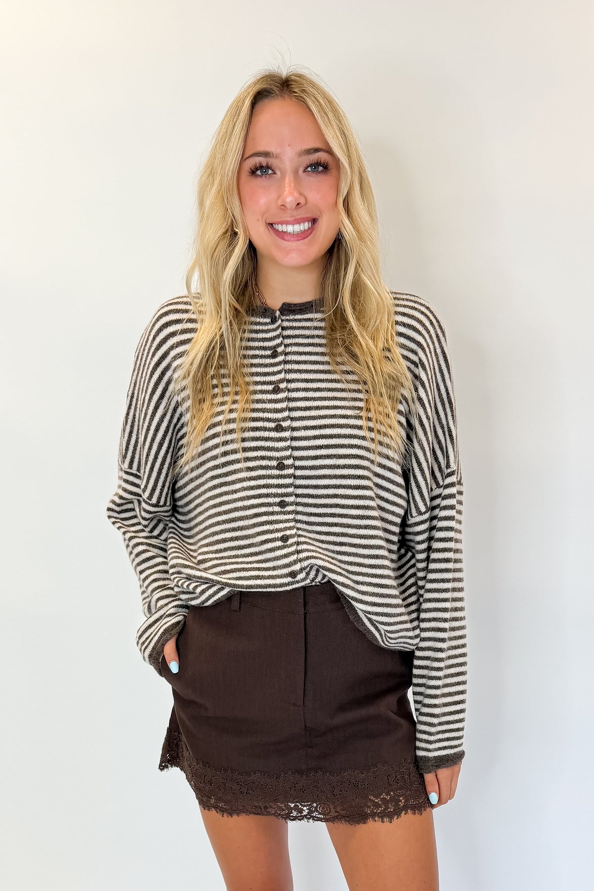 Front view of woman wearing Swagger Boutique’s Brown Lace Lined Denim Skort with top against white studio background.