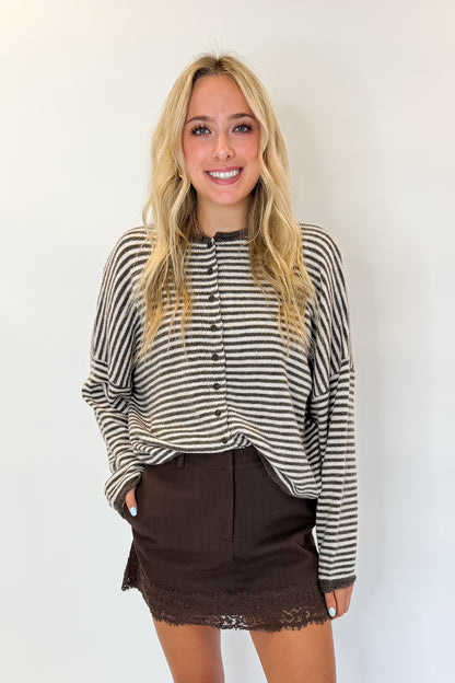 Front view of woman wearing Swagger Boutique’s Brown Lace Lined Denim Skort with top against white studio background.