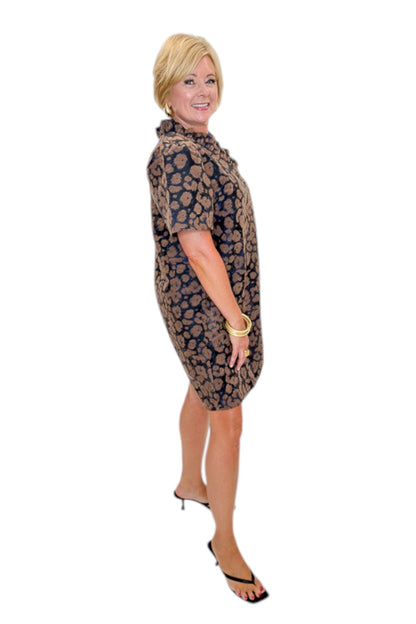 Side view of woman wearing Swagger Boutique’s Brown Leopard Velvet V-Neck Dress with heels against white studio background.