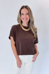 Front view of woman wearing Swagger Boutique’s Brown Light Weight Short Sleeve Sweater with jeans against white studio background.