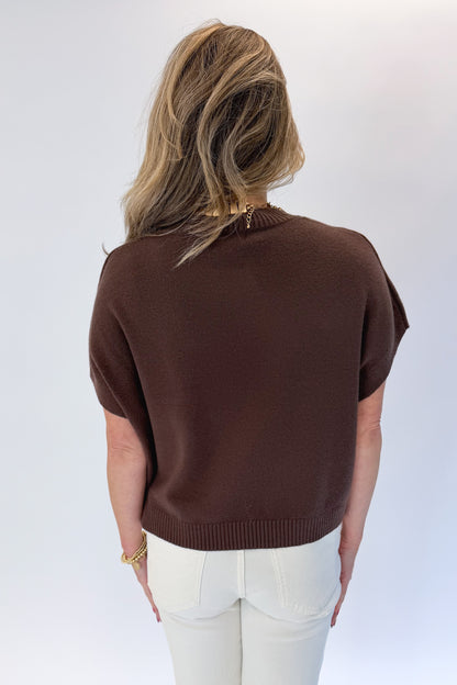 Back view of woman wearing Swagger Boutique’s Brown Light Weight Short Sleeve Sweater with jeans against white studio background.