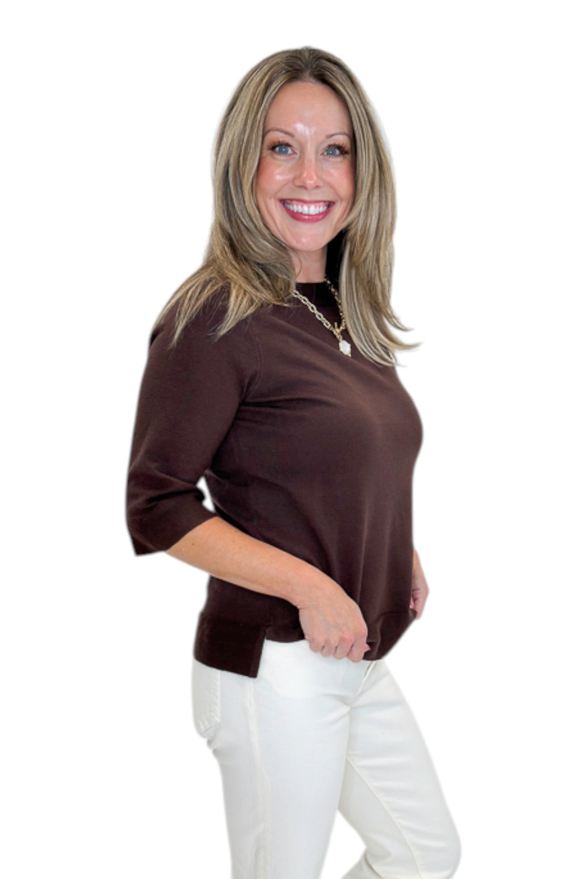 Side view of woman wearing Swagger Boutique’s Brown Lightweight Half Sleeve Sweater with jeans against white studio background.