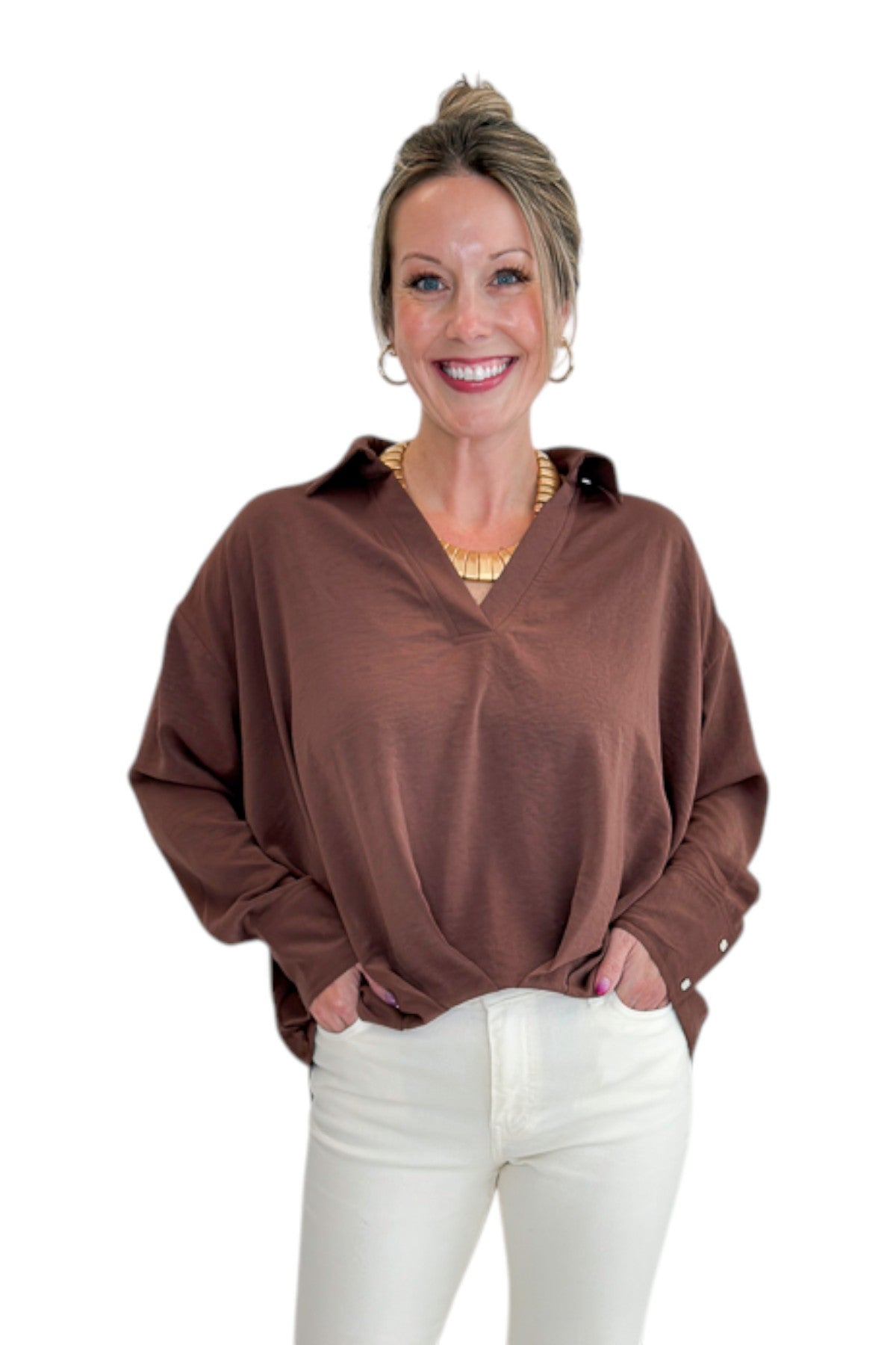 Front view of woman wearing Swagger Boutique’s Brown Pleated Long Sleeve Top by Entro with jeans against white studio background.
