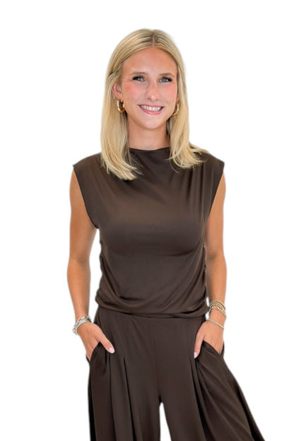 Front view of woman wearing Swagger Boutique’s Brown Pleated Wide Leg Pants with Brown Rouched Side Tank against white studio background.