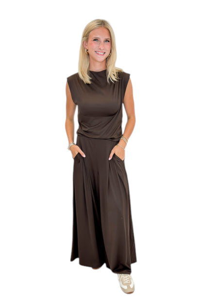 Front view of woman wearing Swagger Boutique’s Brown Pleated Wide Leg Pants with Brown Rouched Side Tank against white studio background.