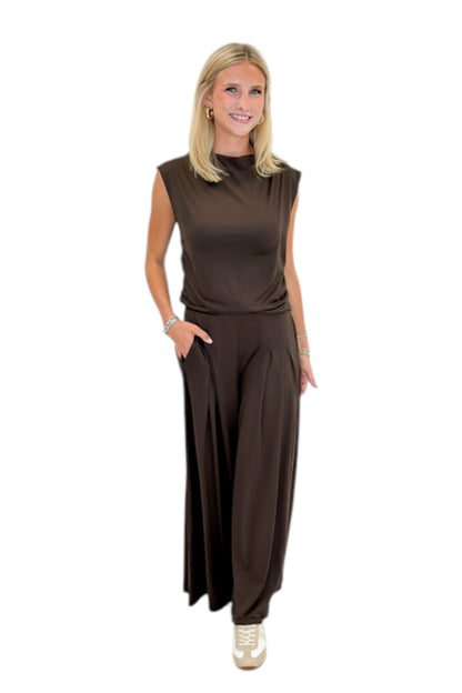 Front view of woman wearing Swagger Boutique’s Brown Pleated Wide Leg Pants with Brown Rouched Side Tank against white studio background.
