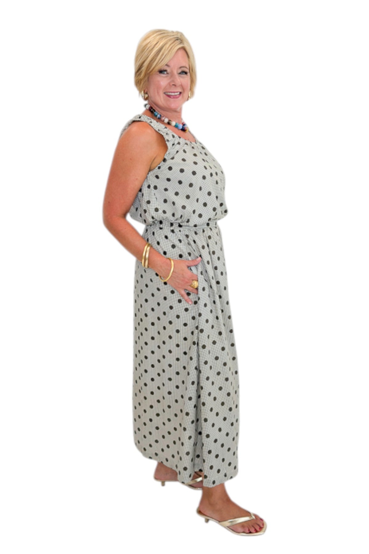 Side view of woman wearing Swagger Boutique’s Brown Polka Dot Bubble Hem Tank and Midi Skirt by Entro against white studio background.