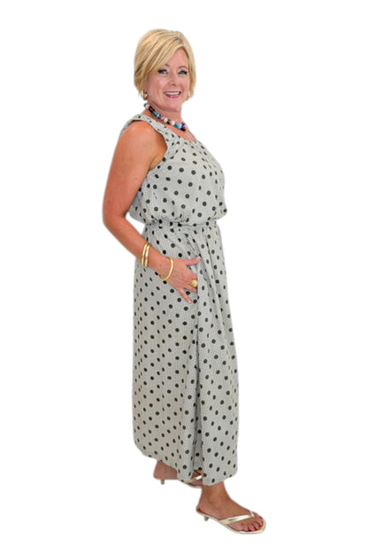 Side view of woman wearing Swagger Boutique’s Brown Polka Dot Bubble Hem Tank and Midi Skirt by Entro against white studio background.