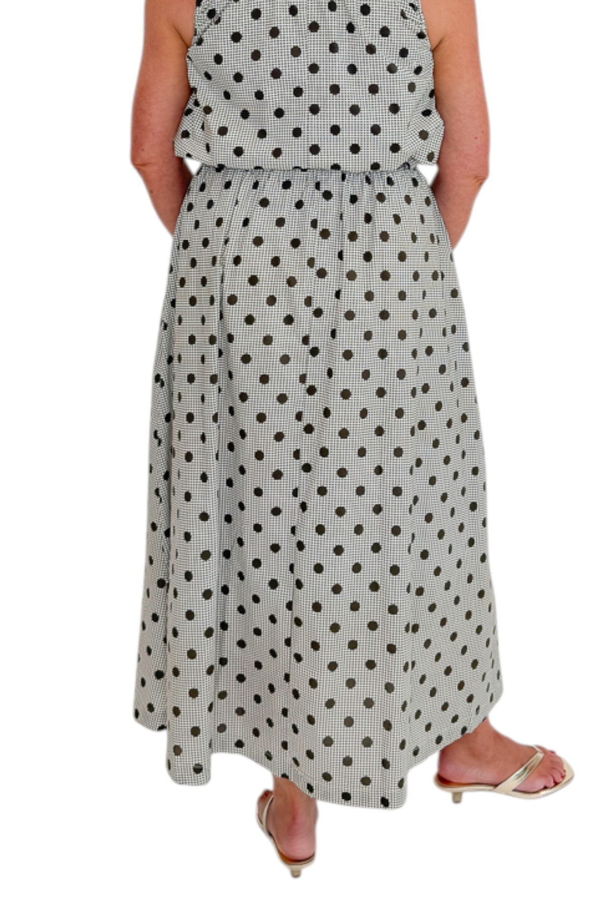 Back view of woman wearing Swagger Boutique’s Brown Polka Dot Bubble Hem Tank and Midi Skirt by Entro against white studio background.