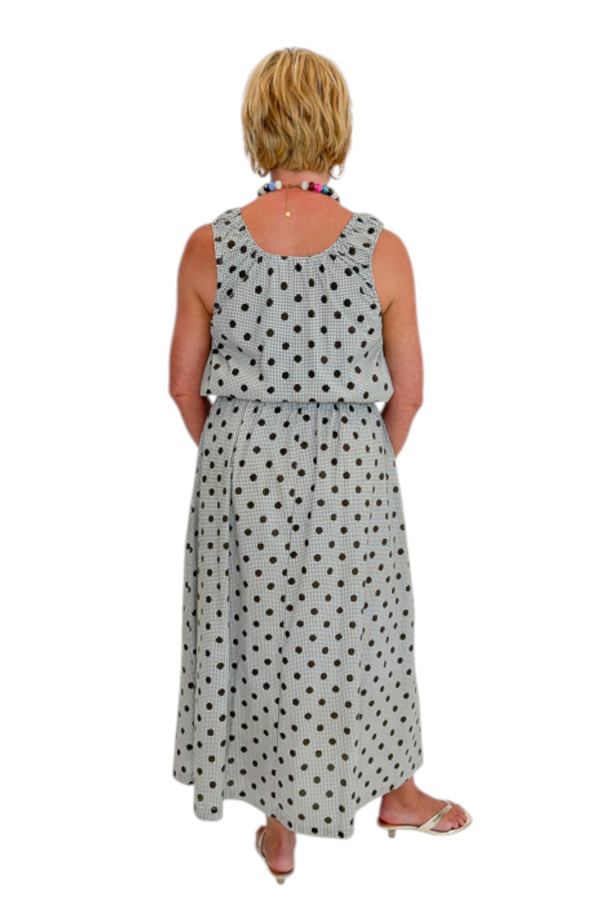 Back view of woman wearing Swagger Boutique’s Brown Polka Dot Bubble Hem Tank and Midi Skirt by Entro against white studio background.