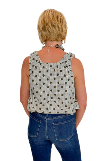 Back view of woman wearing Swagger Boutique’s Brown Polka Dot Bubble Hem Tank with jeans against white studio background.