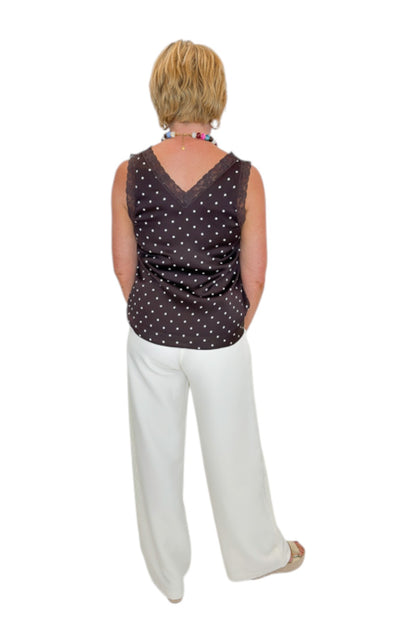 Back view of woman wearing Swagger Boutique’s Brown Polka Dot Lace Trim Tank with Cream Lace Lined Pants against white studio background.