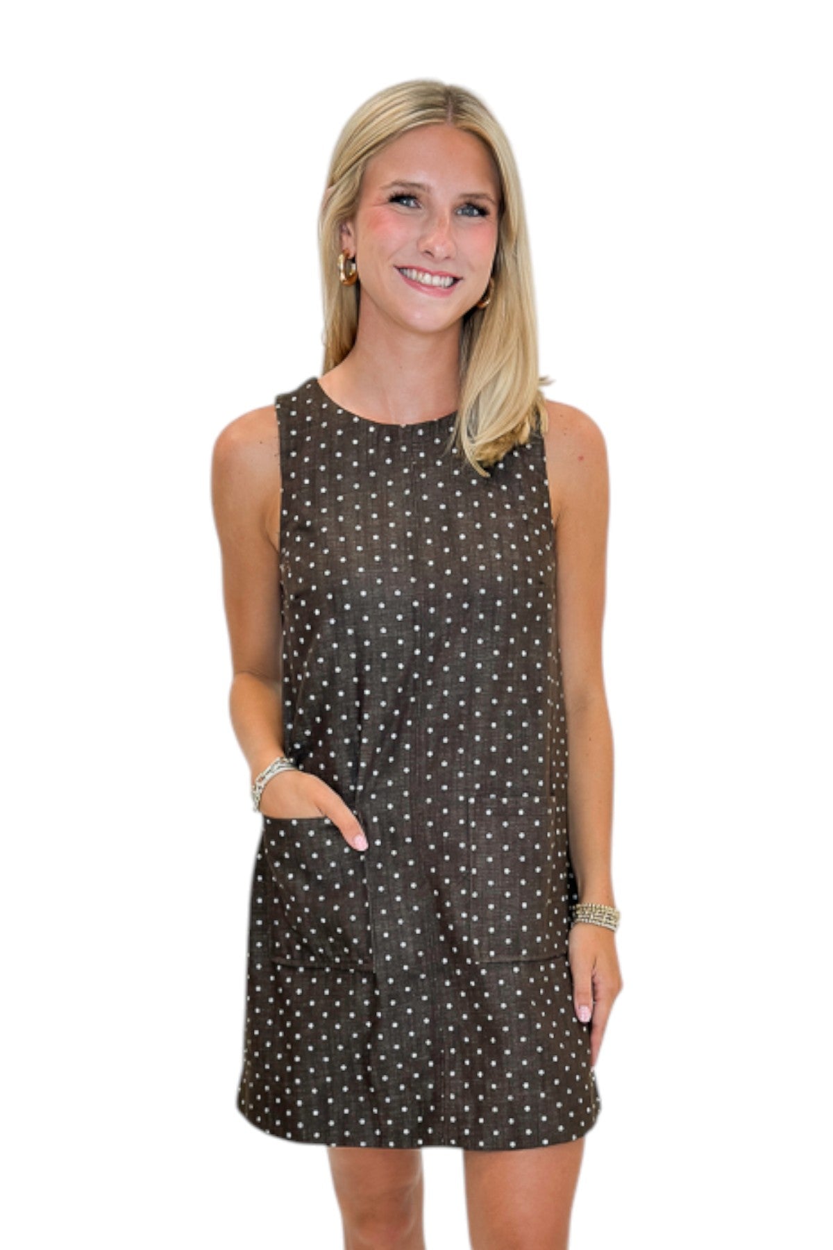 Front view of woman wearing Swagger Boutique’s Brown Polka Dot Shift Dress with boots against white studio background.