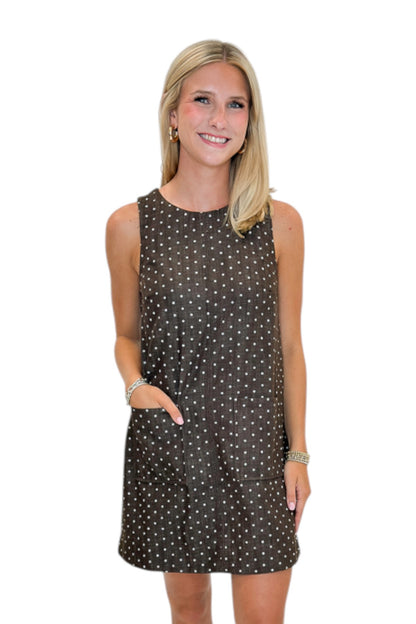 Front view of woman wearing Swagger Boutique’s Brown Polka Dot Shift Dress with boots against white studio background.