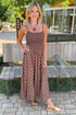Front view of woman wearing Swagger Boutique’s Brown Polka Dot Smocked Midi Dress with sandals standing by a bench outside.