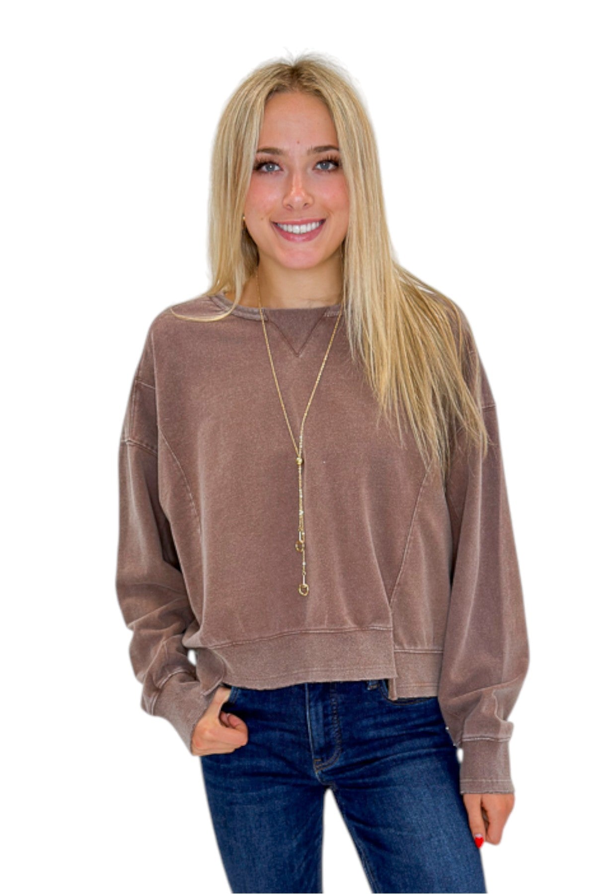 Front view of woman wearing Swagger Boutique’s Brown Ribbed Detail Sweatshirt with jeans against white studio background.