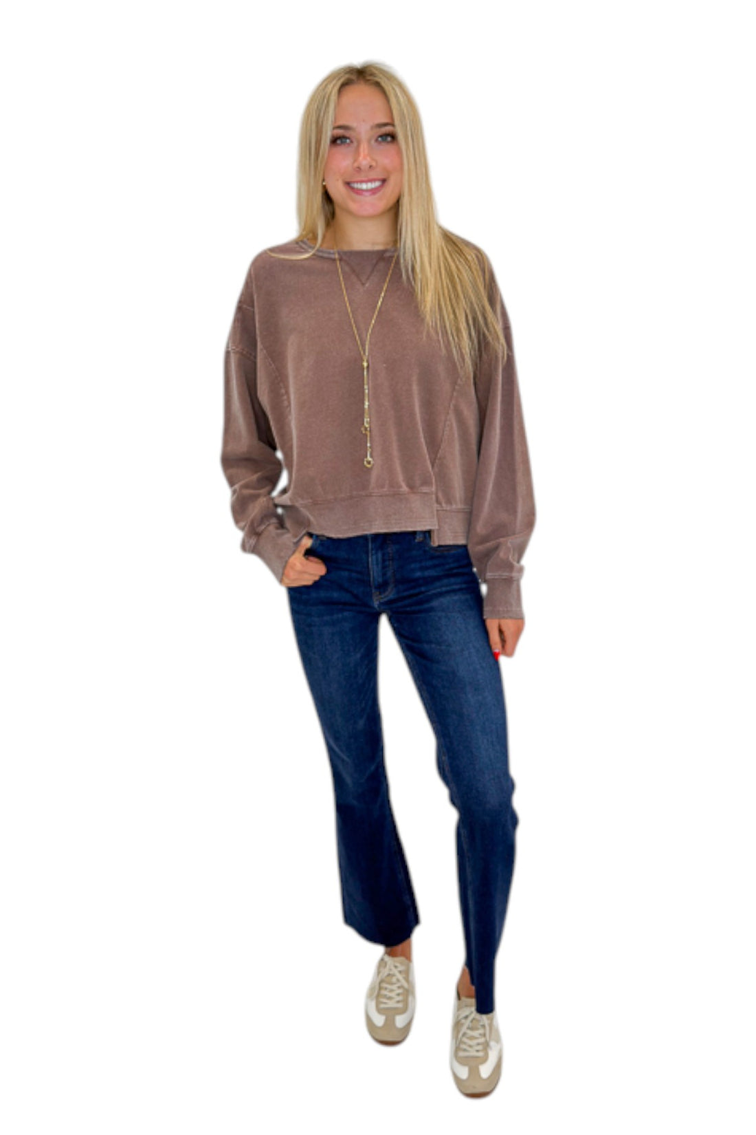 Front view of woman wearing Swagger Boutique’s Brown Ribbed Detail Sweatshirt with jeans against white studio background.