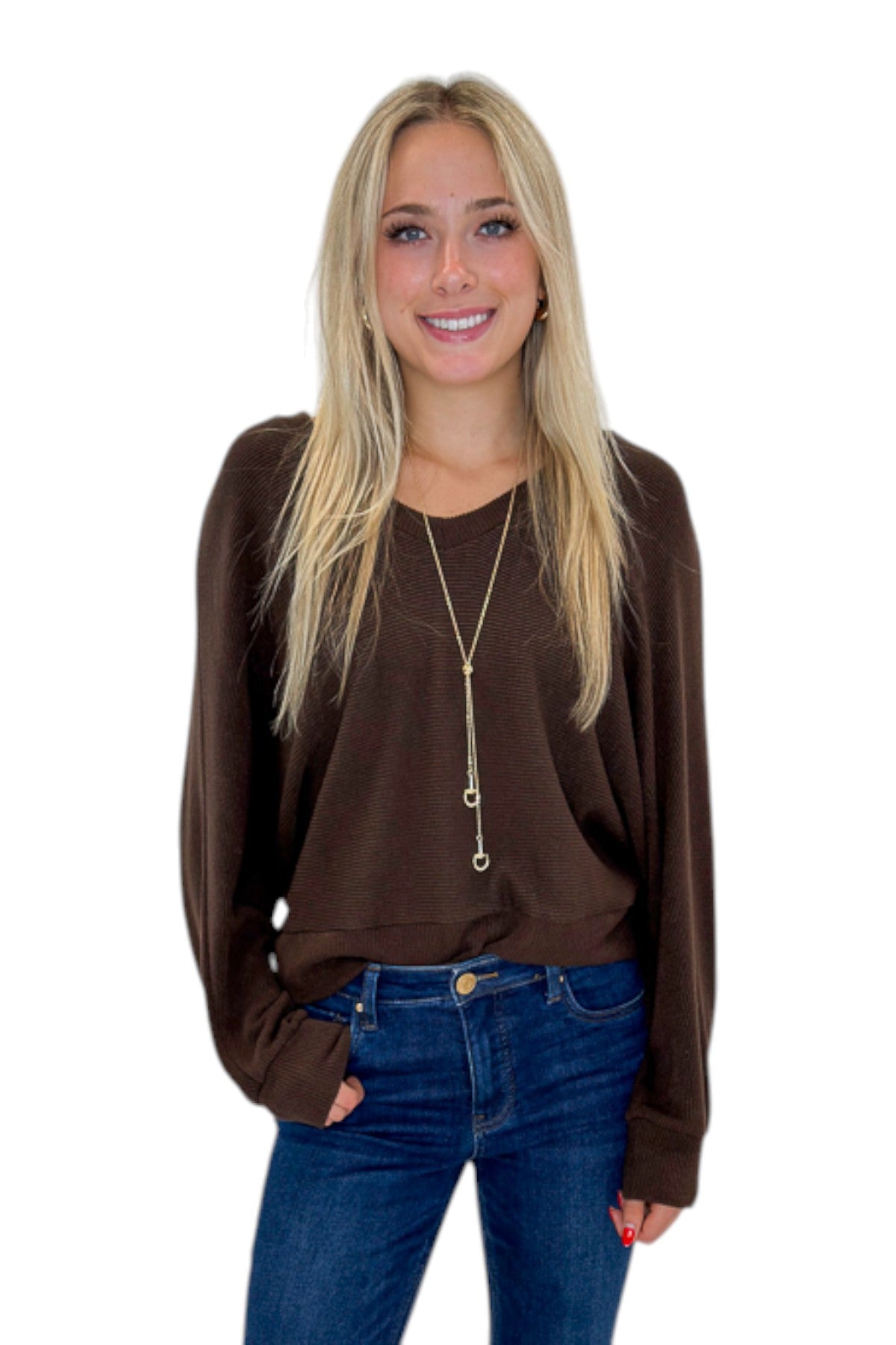 Front view of woman wearing Swagger Boutique’s Brown Ribbed V-neck Banded Top with jeans against white studio background.