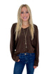 Front view of woman wearing Swagger Boutique’s Brown Ribbed V-neck Banded Top with jeans against white studio background.
