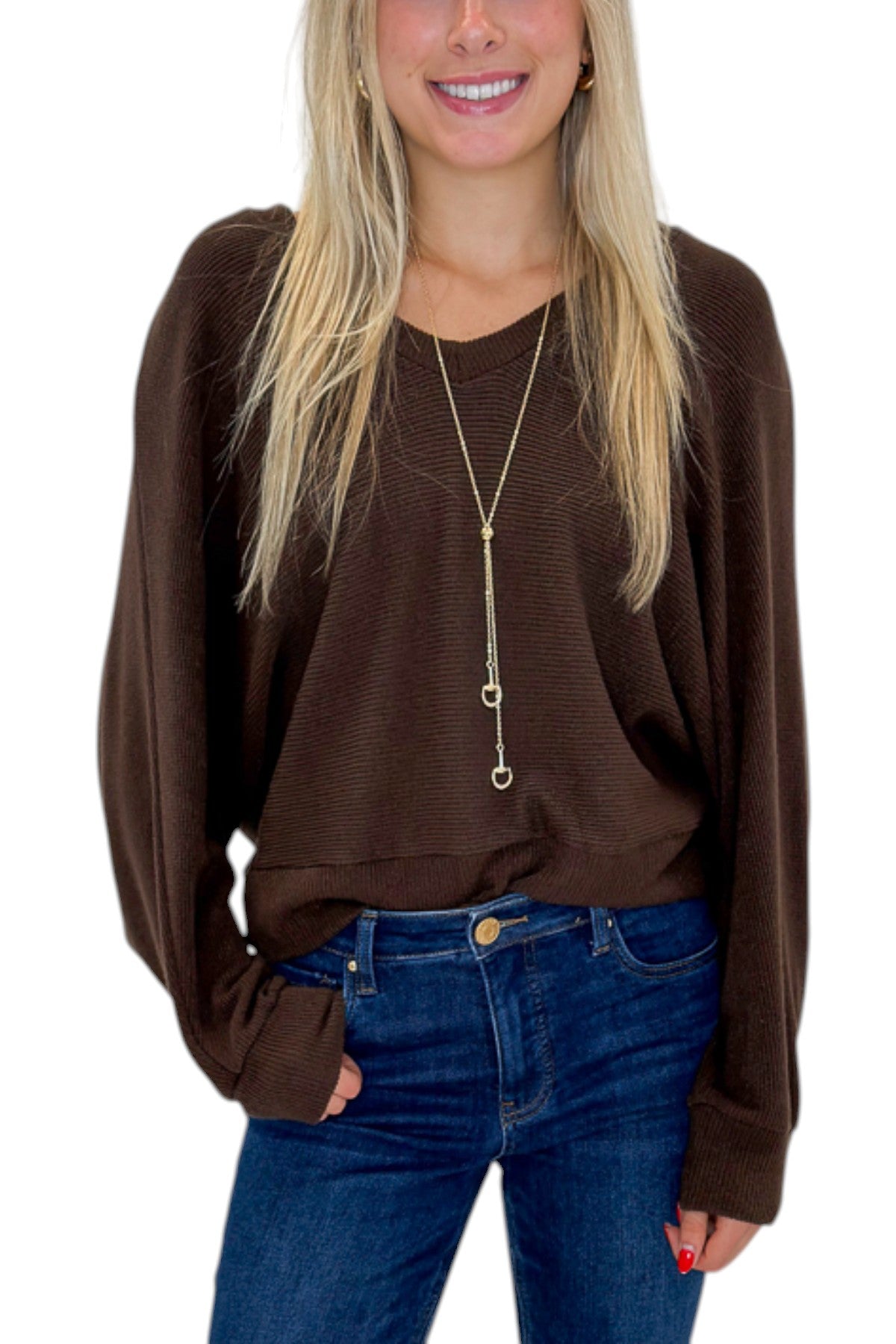 Front detail view of woman wearing Swagger Boutique’s Brown Ribbed V-neck Banded Top with jeans against white studio background.