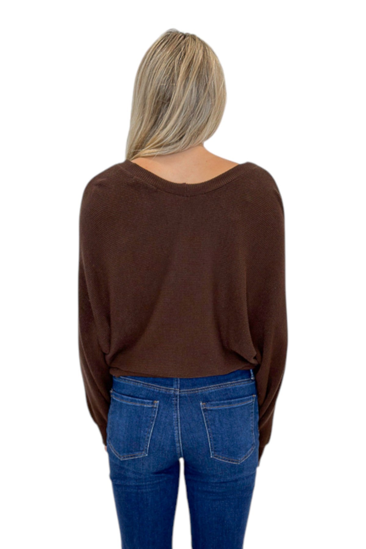 Back view of woman wearing Swagger Boutique’s Brown Ribbed V-neck Banded Top with jeans against white studio background.