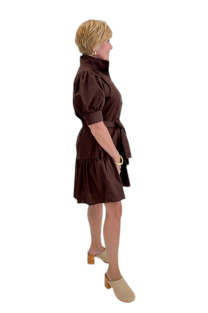 Side view of woman wearing Swagger Boutique’s Brown Ruffle Mini Dress by Entro against white studio background.