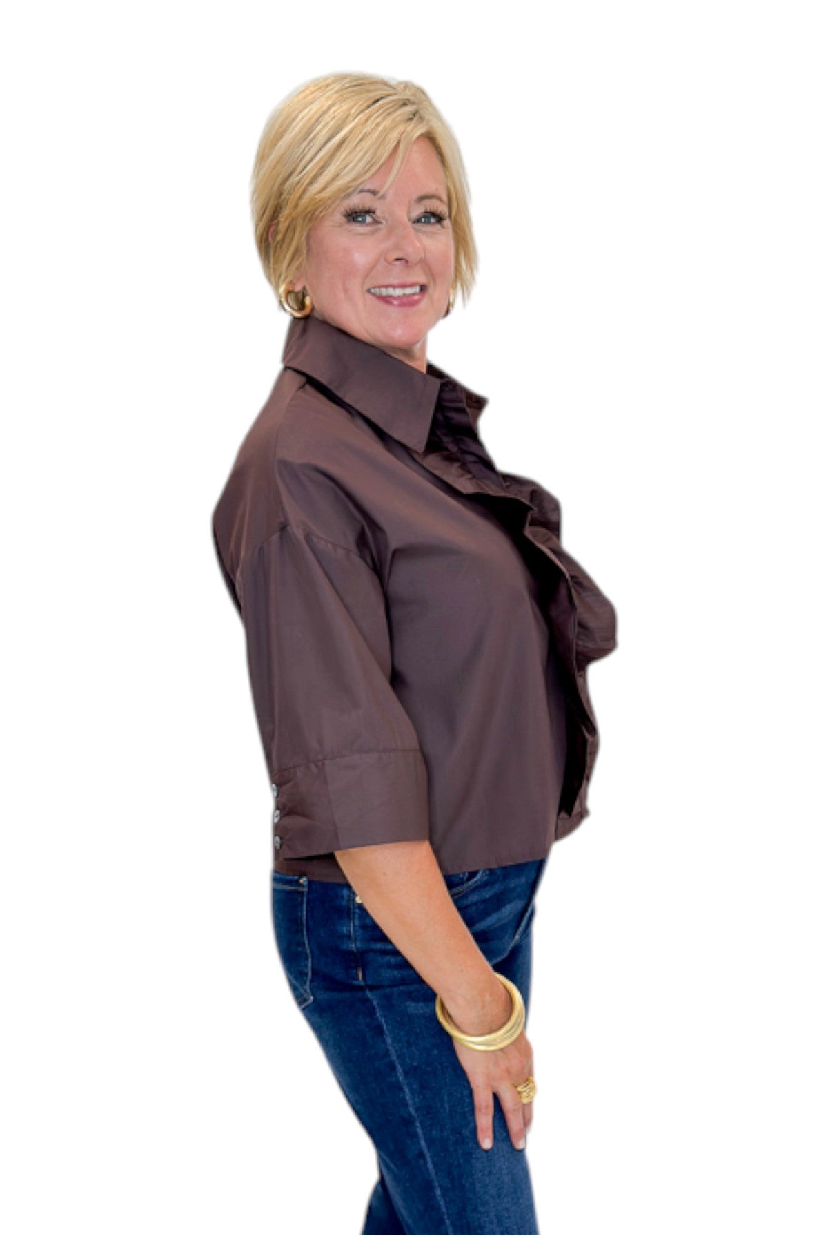 Side view of woman wearing Swagger Boutique’s Brown Ruffle Trim 3/4 Sleeve Top by Entro with jeans against white studio background.