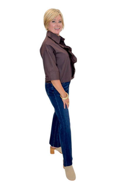 Side view of woman wearing Swagger Boutique’s Brown Ruffle Trim 3/4 Sleeve Top by Entro with jeans against white studio background.