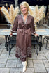 Front view of woman wearing Swagger Boutique’s Brown Satin Embroidered Midi Dress standing outside at a party.