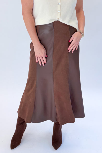 Front detail view of woman wearing Swagger Boutique’s Cream Sleeveless Button Up Sweater with Brown Suede &amp; Leather Midi Skirt by THML against white studio background.
