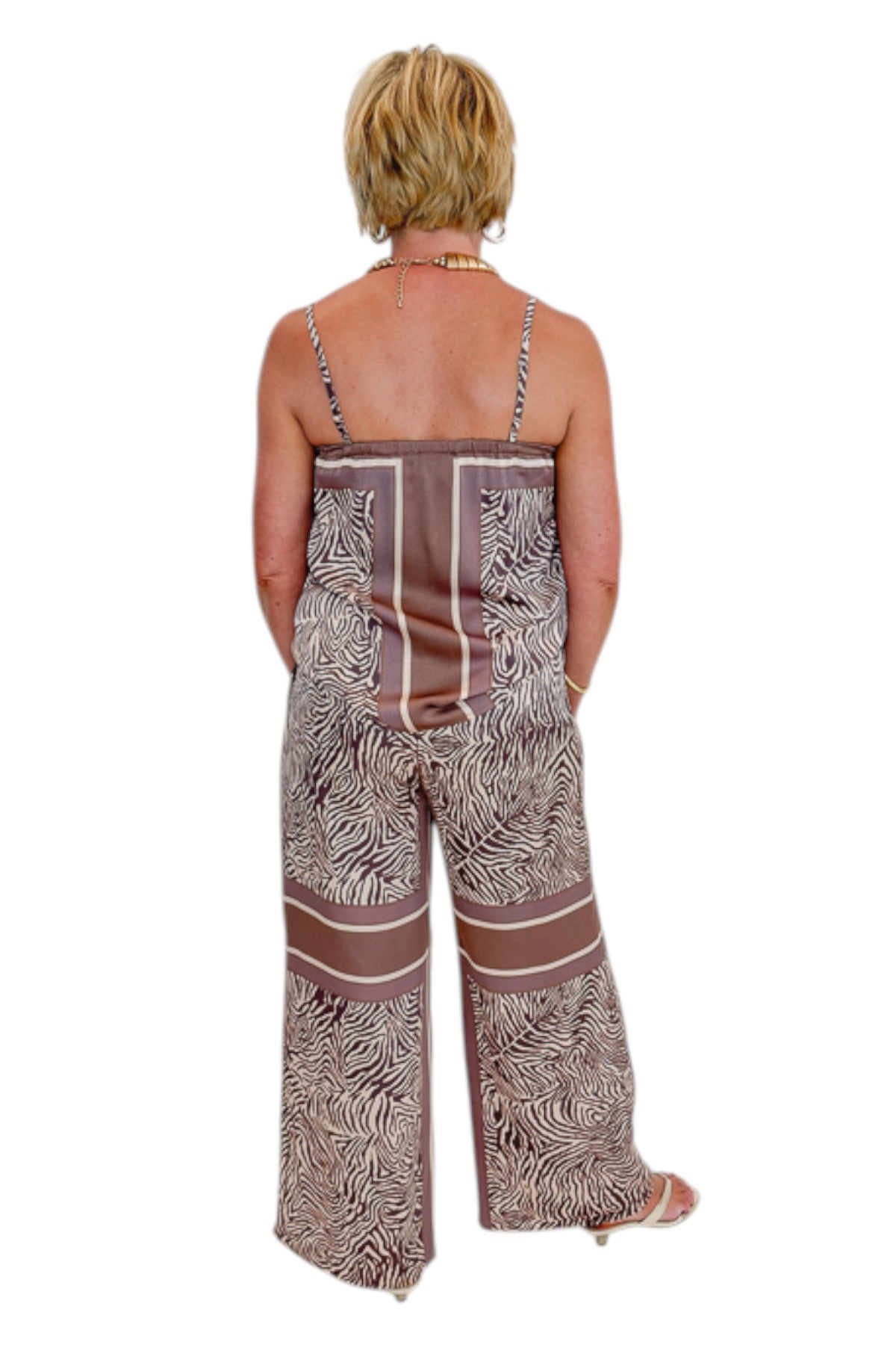 Back view of woman wearing Swagger Boutique’s Brown Zebra Tank by Entro with Wide Leg Pants against white studio background.