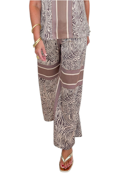 Front view of woman wearing Swagger Boutique’s Brown Zebra Tank by Entro with Wide Leg Pants against white studio background.