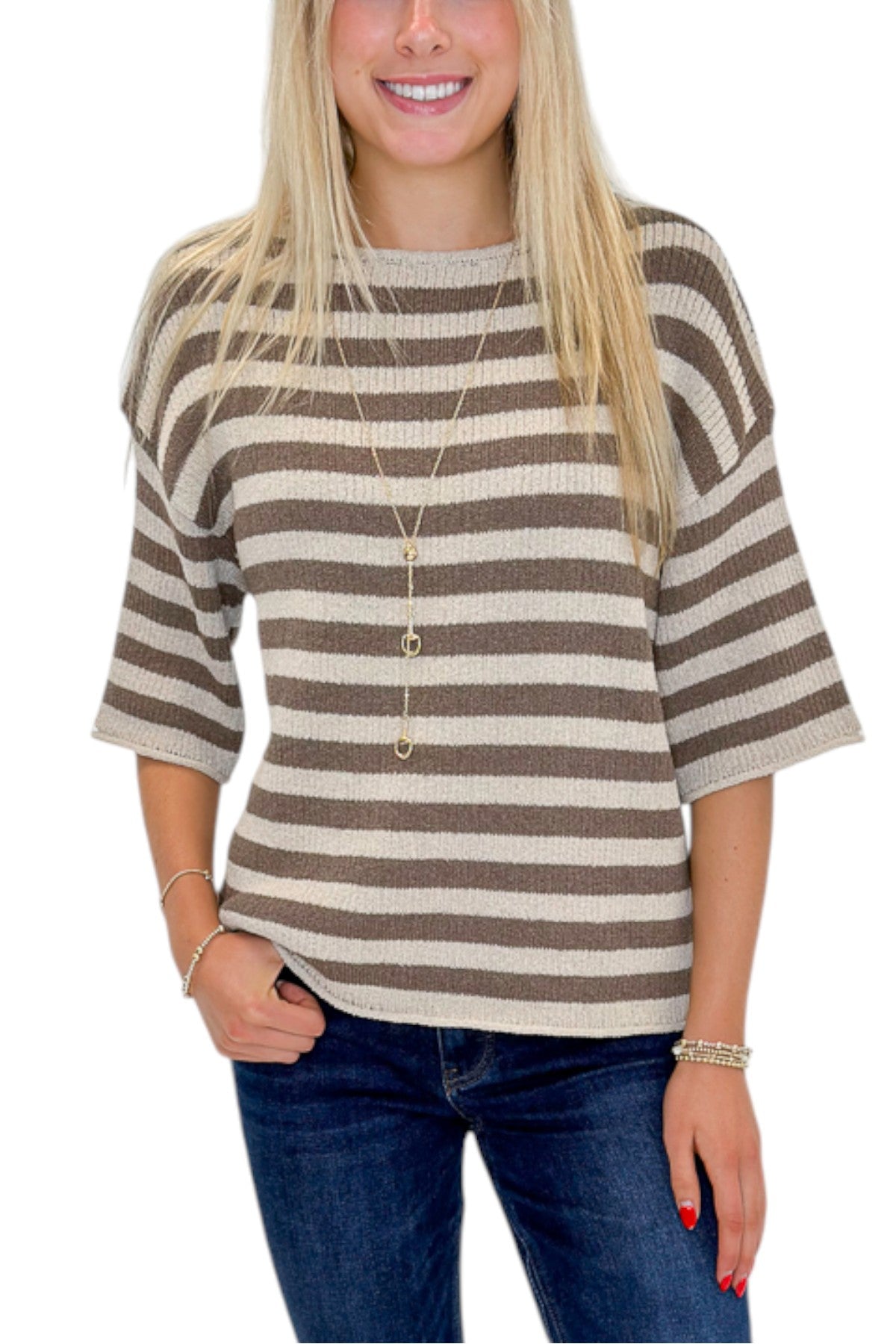 Front detail view of woman wearing Swagger Boutique’s Brown &amp; Beige Striped Short Sleeve Sweater with jeans against white studio background.