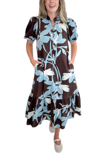 Front detail view of woman wearing Swagger Boutique’s Brown &amp; Blue Floral Midi Dress by Entro against white studio background.