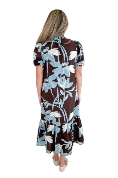 Back view of woman wearing Swagger Boutique’s Brown &amp; Blue Floral Midi Dress by Entro against white studio background.