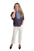 Front view of woman wearing Swagger Boutique’s Brown & Blue Polka Dot Dolman Sleeve Top by Entro with jeans against white studio background.