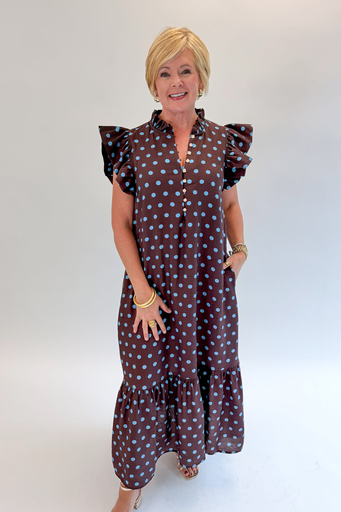 Front view of woman wearing Swagger Boutique’s Brown &amp; Blue Polka Dot Midi Dress by Entro with heels against white studio background. 