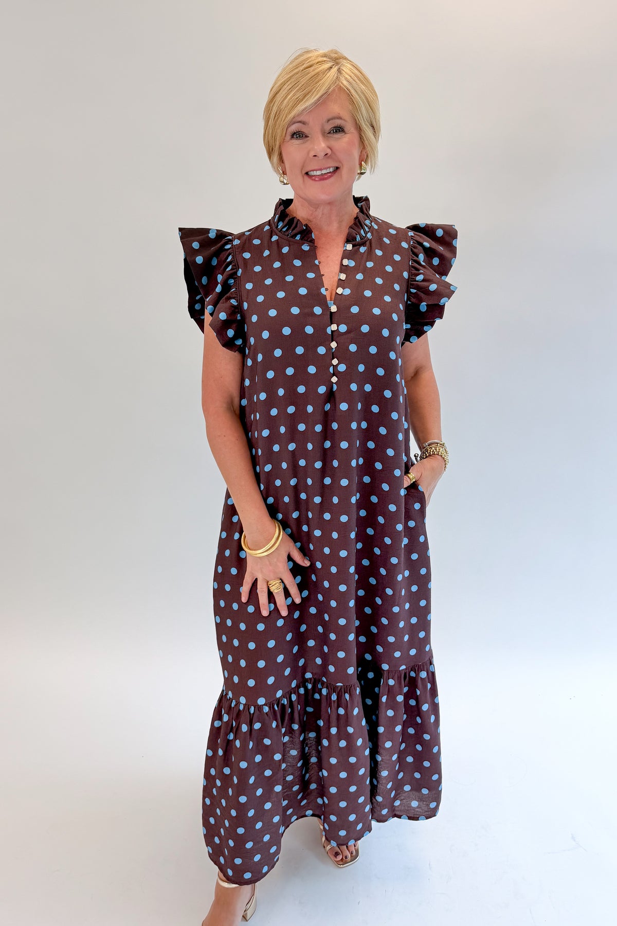 Front view of woman wearing Swagger Boutique’s Brown &amp; Blue Polka Dot Midi Dress by Entro with heels against white studio background. 