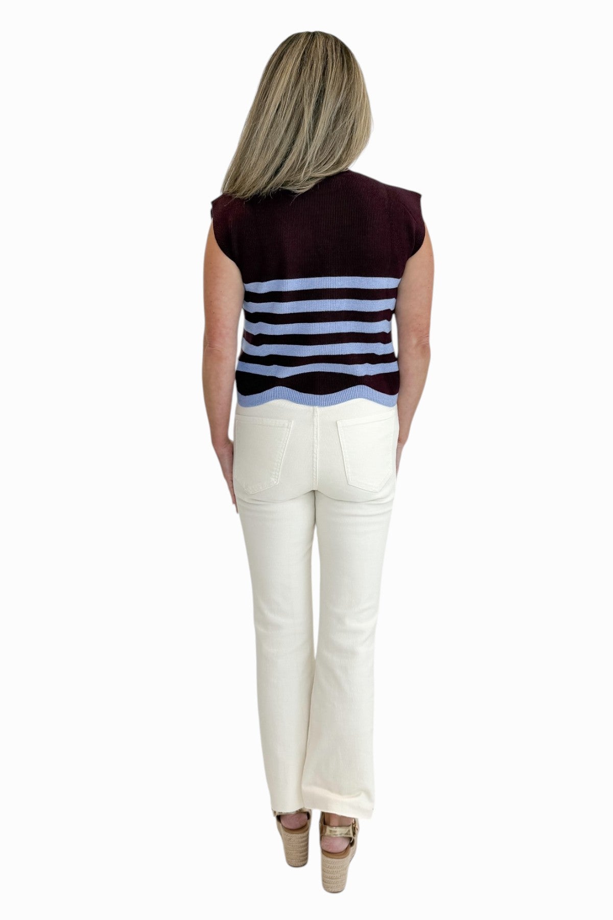 Back view of woman wearing Swagger Boutique’s Brown &amp; Blue Scallop Hem Sleeveless Sweater by Entro with Ecru jeans against white studio background.