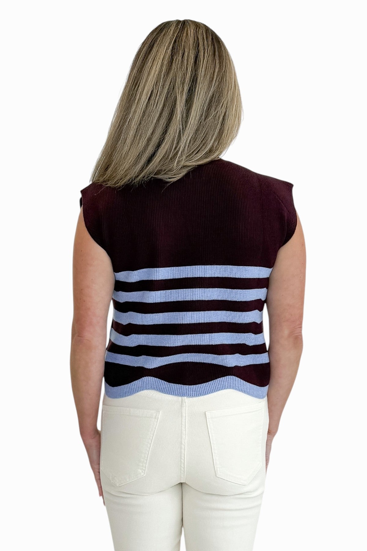 Back view of woman wearing Swagger Boutique’s Brown &amp; Blue Scallop Hem Sleeveless Sweater by Entro with jeans against white studio background.