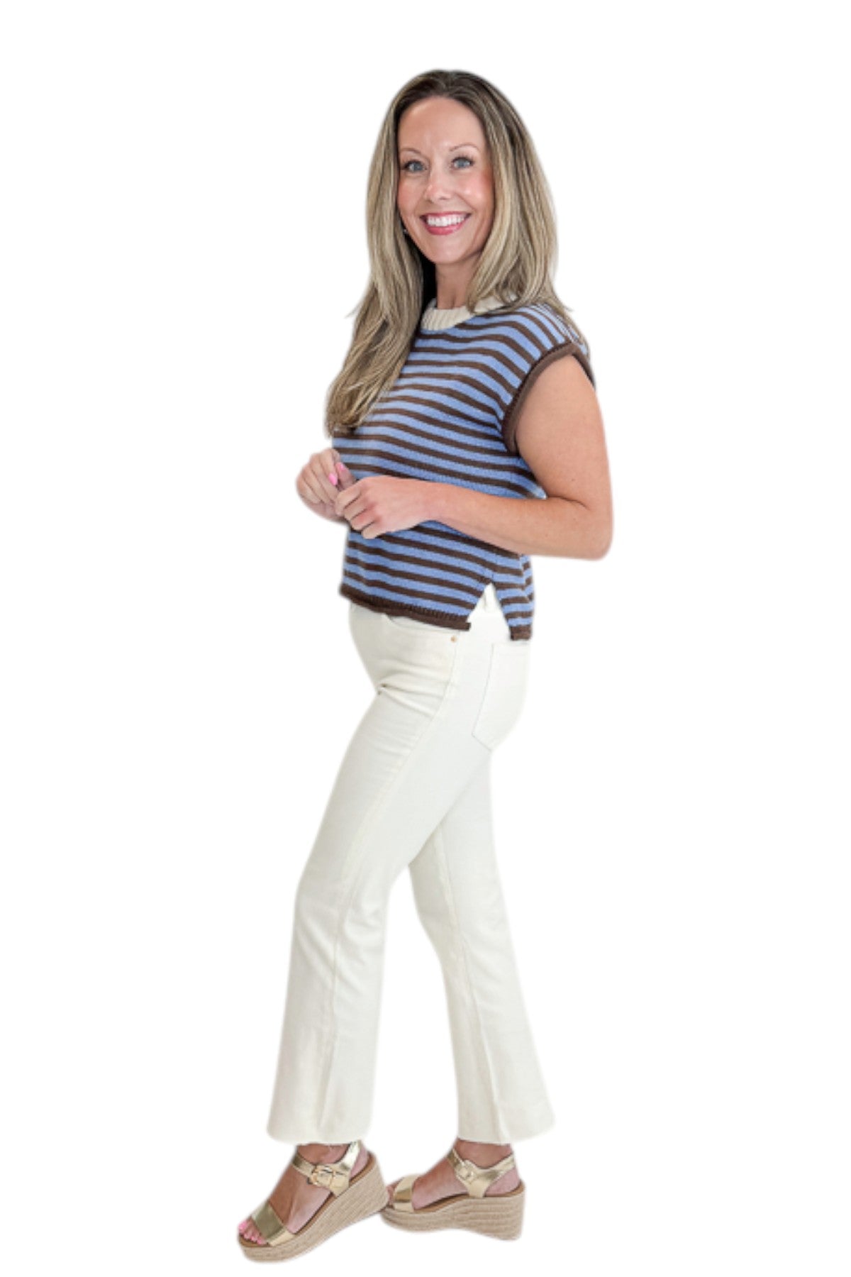 Side view of woman wearing Swagger Boutique’s Brown &amp; Blue Striped Sleeveless Sweater by Entro with jeans against white studio background.
