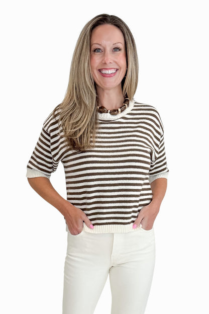 Front view of woman wearing Swagger Boutique’s Brown &amp; Cream Striped Short Sleeve Sweater with jeans against white studio background.