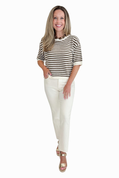 Front view of woman wearing Swagger Boutique’s Brown &amp; Cream Striped Short Sleeve Sweater with jeans against white studio background.