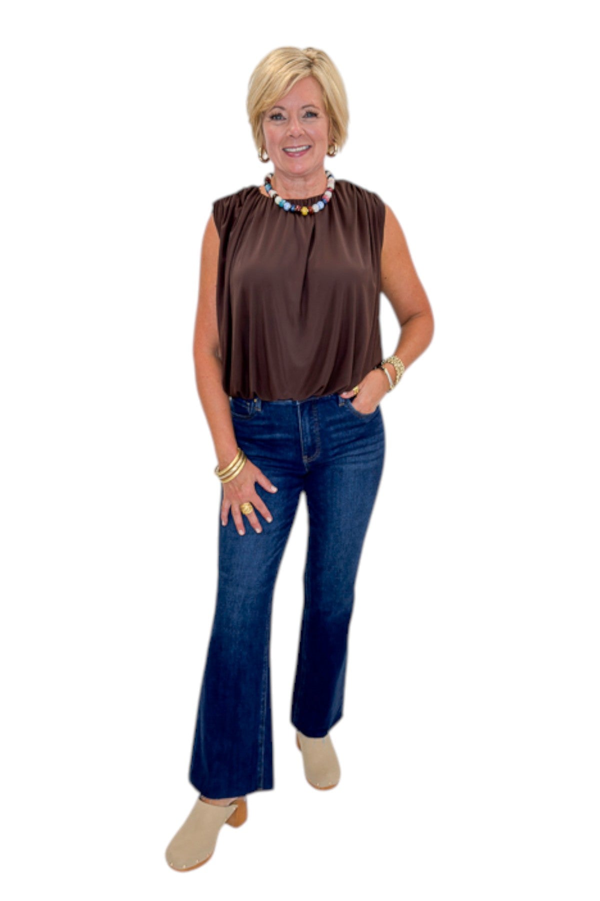 Front view of woman wearing Swagger Boutique’s Brown Mesh Bubble Hem Top with jeans against white studio background.