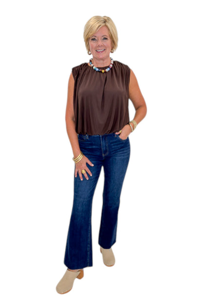 Front view of woman wearing Swagger Boutique’s Brown Mesh Bubble Hem Top with jeans against white studio background.